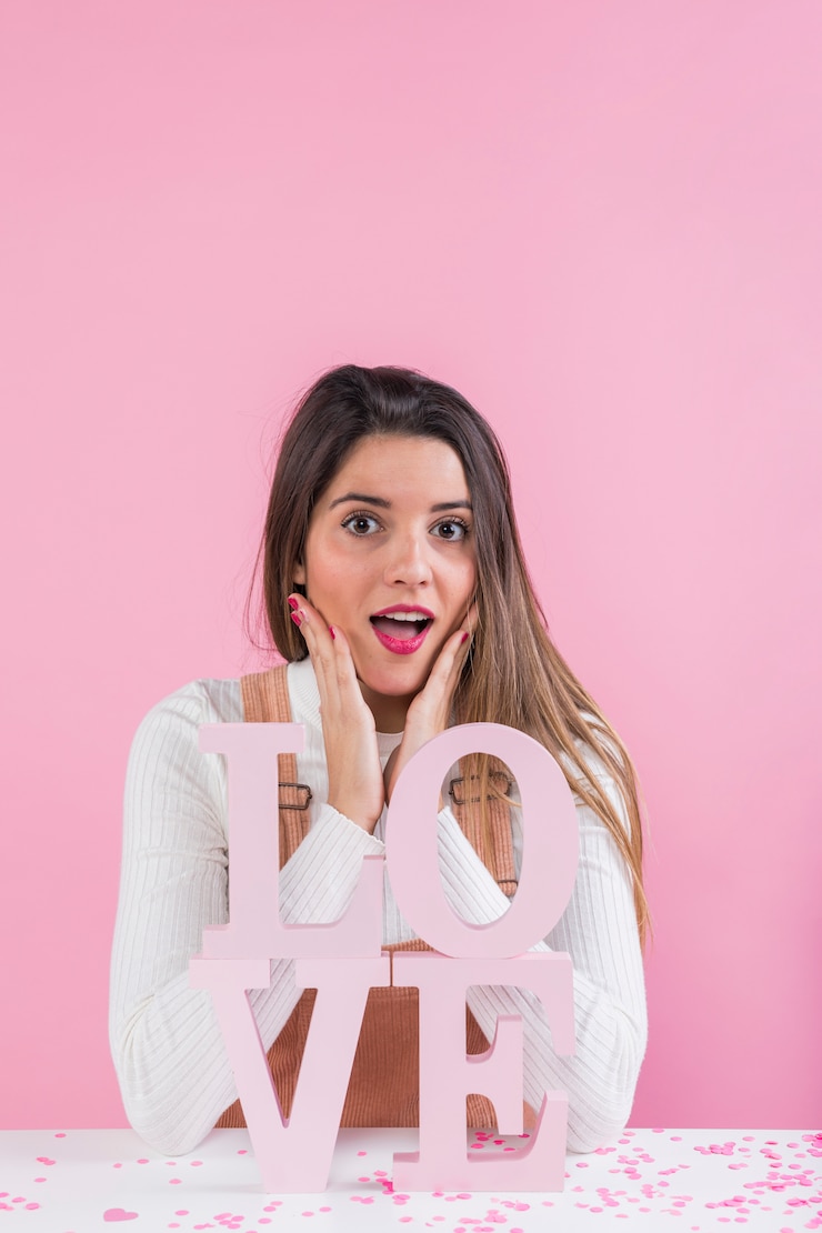Foto gratuito mujer sorprendida de pie cerca de la inscripción de amor
