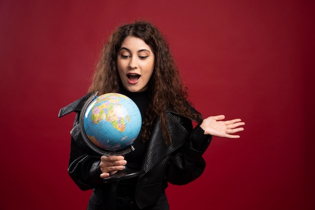 Mujer sorprendida que sostiene el globo.