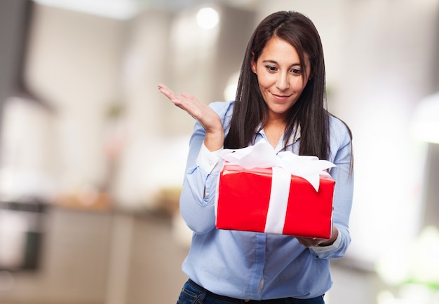 Mujer sorprendida con un regalo rojo