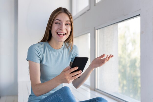 Mujer sorprendida sosteniendo su teléfono