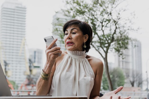 Mujer sorprendida sosteniendo un teléfono plano medio