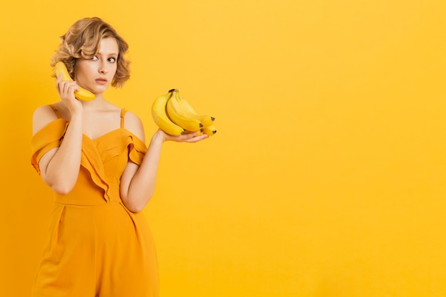 Foto gratuita mujer sorprendida usando banana como teléfono