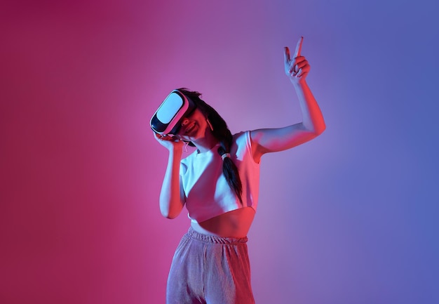 Mujer sorprendida usando un casco de realidad virtual jugando videojuegos tratando de tocar algo con la mano