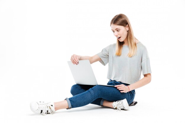 Mujer sorprendida usando la computadora portátil