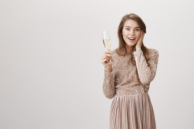 Foto gratuita mujer sorprendida en vestido de noche con copa de champán