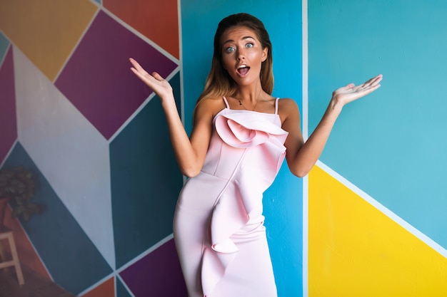 Mujer sorprendida en el vestido rosa, modelo de moda