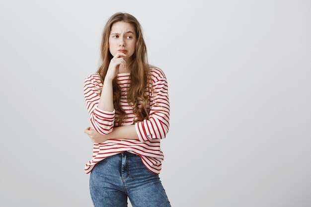 Mujer sospechosa pensativa haciendo suposición, apartar la mirada reflexionando