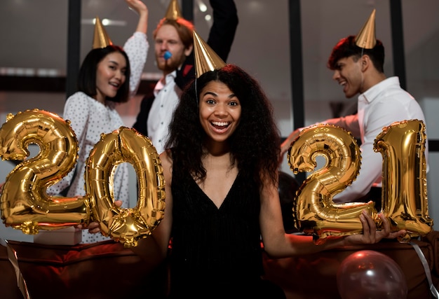 Mujer sosteniendo 2021 globos en fiesta