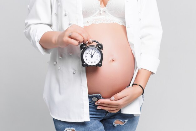 Mujer sosteniendo alarma negra sobre su barriga