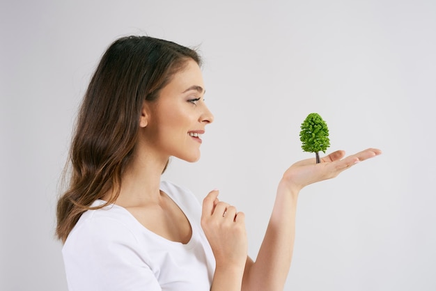 Foto gratuita mujer sosteniendo un árbol en su mano