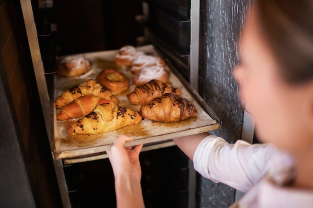 Mujer sosteniendo la bandeja con croissant de cerca