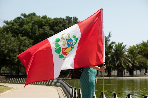 Foto gratuita mujer sosteniendo la bandera de perú