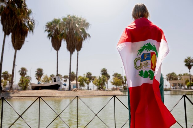 Foto gratuita mujer sosteniendo la bandera de perú