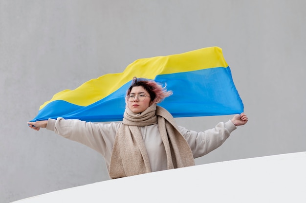 Mujer sosteniendo bandera ucraniana tiro medio