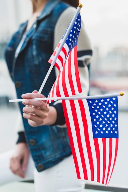 Mujer sosteniendo banderas americanas en el día de la independencia