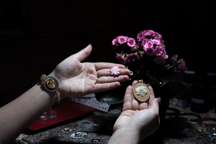 Foto gratuito mujer sosteniendo un bijouterie floral dorado