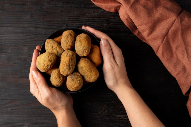 Mujer sosteniendo un bol con croquetas