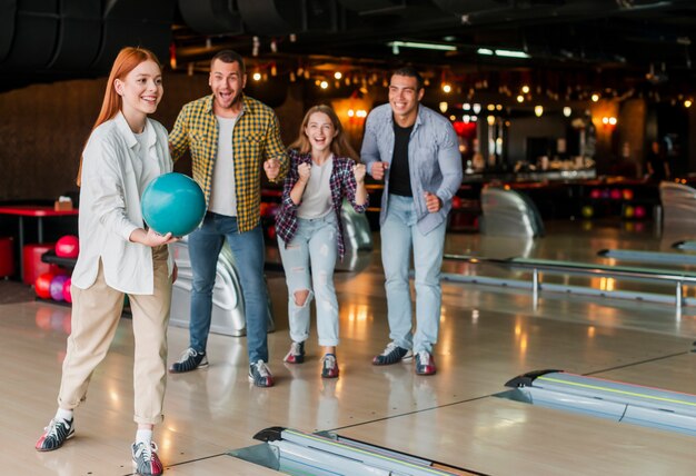 Mujer sosteniendo una bola de boliche en un club de bolos