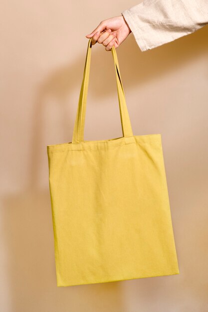 Mujer sosteniendo una bolsa amarilla en su mano