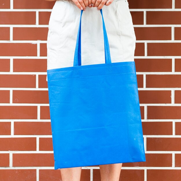 Mujer sosteniendo una bolsa azul