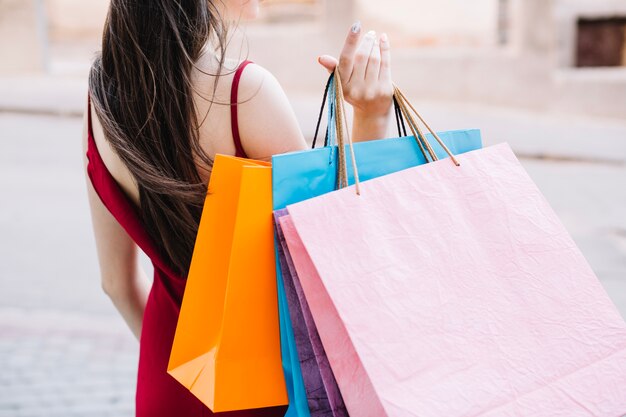 Mujer sosteniendo bolsas de papel en una mano