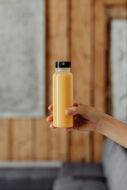 Foto gratuita mujer sosteniendo una botella de jugo de naranja