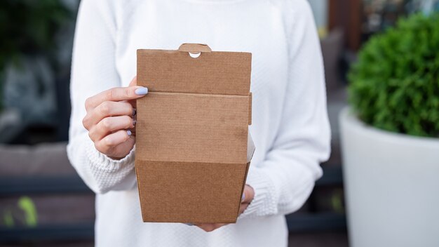 Foto gratuita mujer sosteniendo una caja de comida de papel reciclable. idea de reciclaje