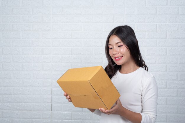 Mujer sosteniendo una caja de correos marrón Hizo gestos con lenguaje de señas.