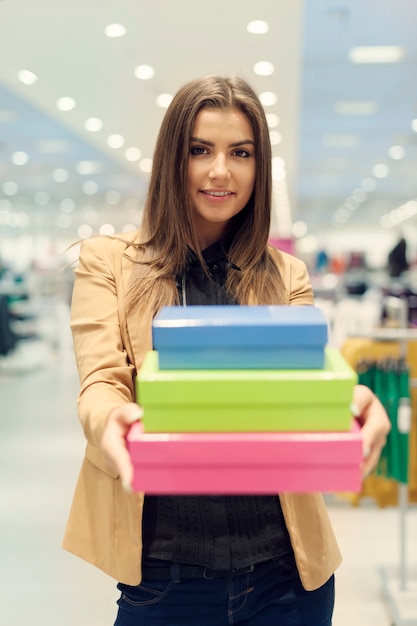 Mujer sosteniendo cajas de compras