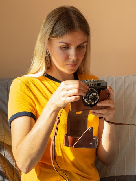 Mujer sosteniendo una cámara de fotos retro