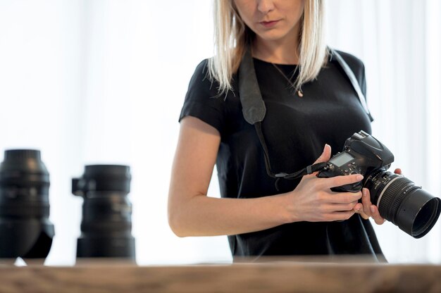 Mujer sosteniendo una cámara profesional y lente