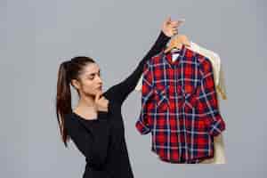Foto gratuita mujer sosteniendo camisas, eligiendo qué ropa usar