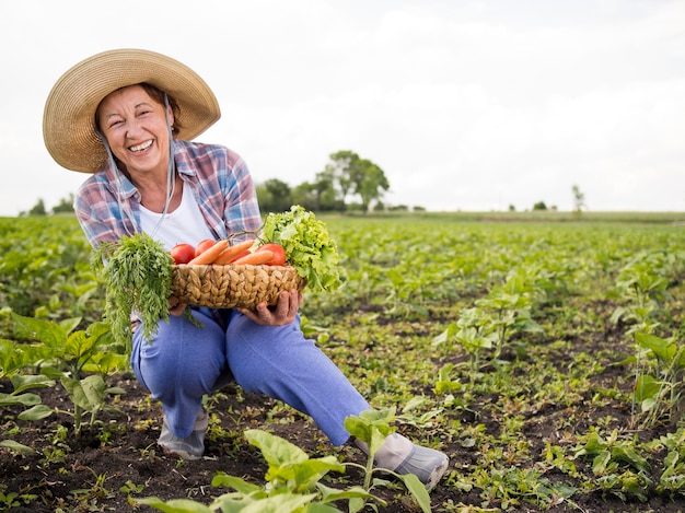 Mujer sosteniendo una canasta llena de verduras con espacio de copia