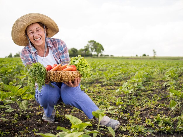 Mujer sosteniendo una canasta llena de verduras con espacio de copia