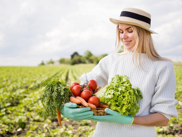 Mujer sosteniendo una canasta llena de verduras