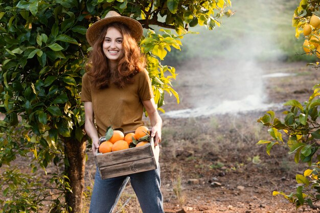 Mujer sosteniendo una canasta con naranjas