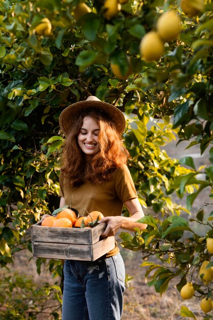 Mujer sosteniendo una canasta con naranjas