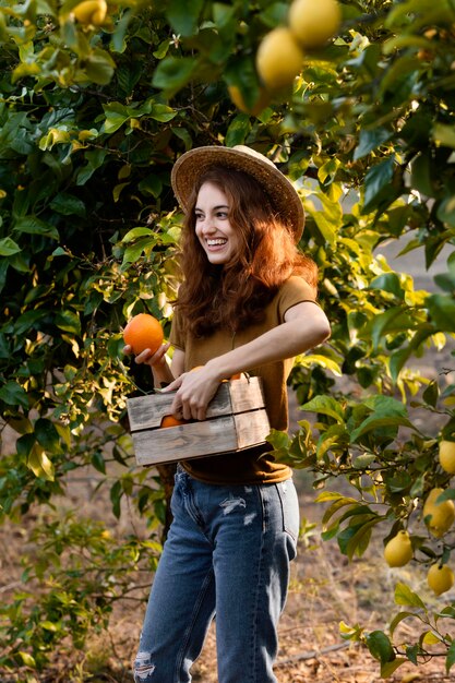 Mujer sosteniendo una canasta con naranjas