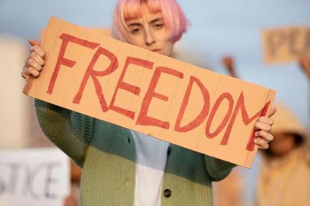Mujer sosteniendo un cartel de libertad de cerca
