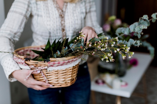 Mujer sosteniendo la cesta con flores