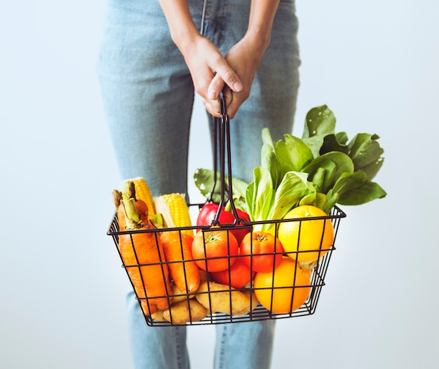 Mujer sosteniendo cesta de vegetales