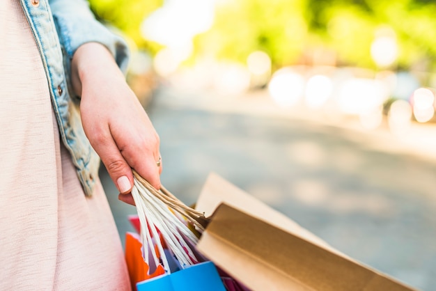 Mujer sosteniendo coloridos bolsos de compras en la mano