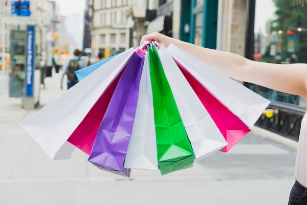 Mujer sosteniendo coloridos bolsos de compras