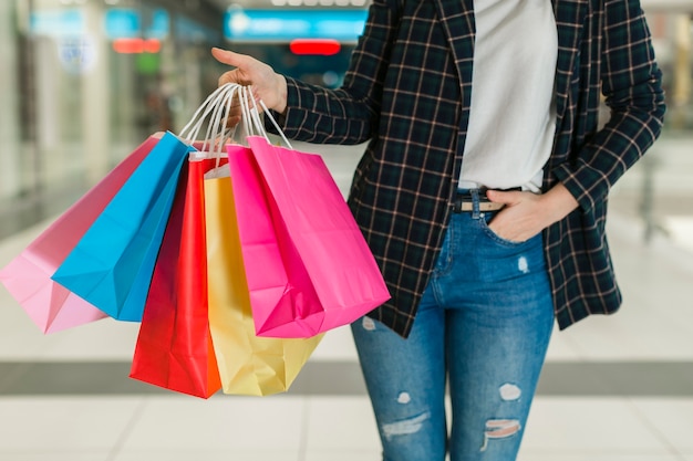 Mujer sosteniendo coloridos bolsos de compras