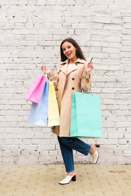 Foto gratuita mujer sosteniendo compras y bolsa y tarjeta de crédito al aire libre