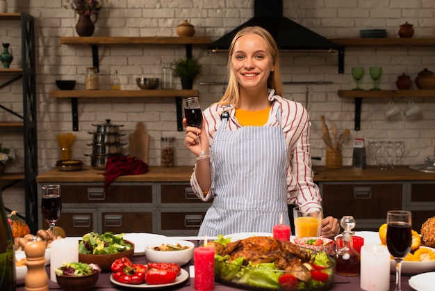 Mujer sosteniendo una copa de vino tinto y una sonrisa