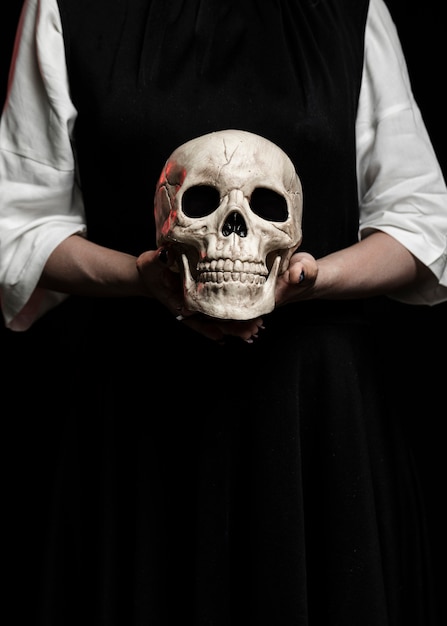 Mujer sosteniendo cráneo humano con espacio de copia