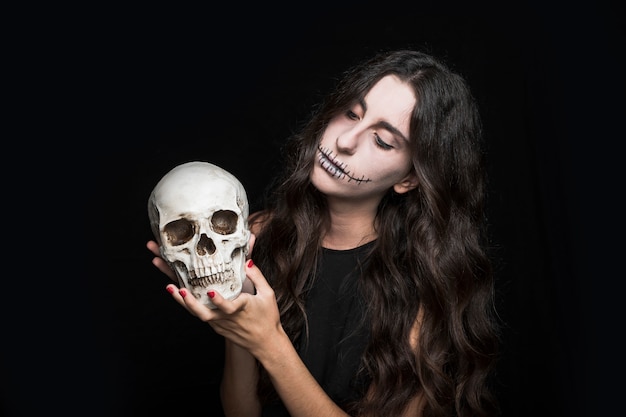 Foto gratuita mujer sosteniendo el cráneo