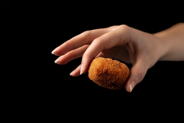 Foto gratuita mujer sosteniendo una croqueta con los dedos