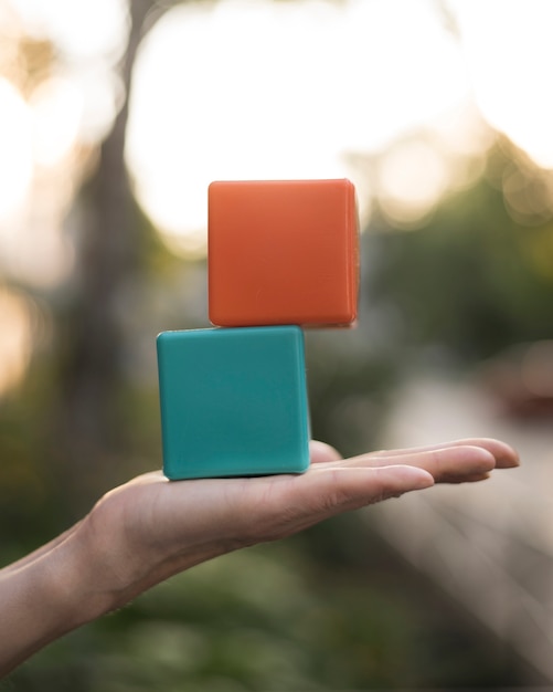 Mujer sosteniendo cubos de colores apilados